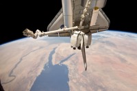 der Canadarm2 der ISS über dem Frachtraum der „Discovery“